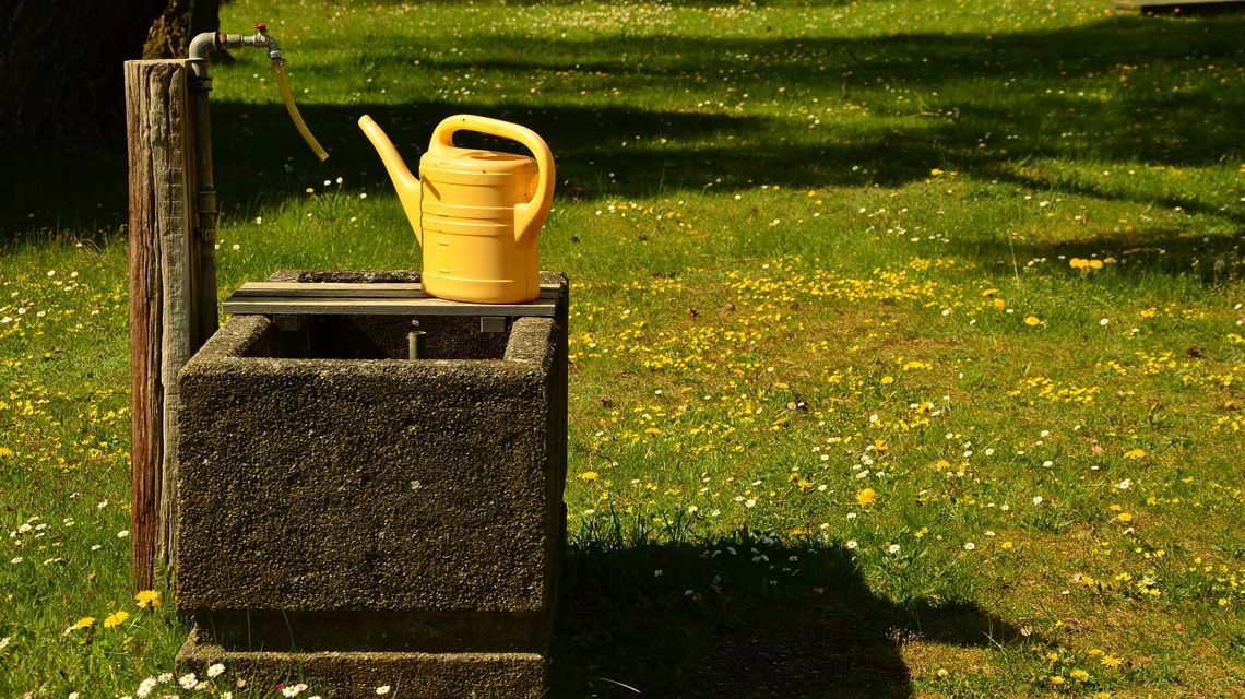 Gießkanne auf dem Friedhof am Brunnen, Grabsteine werden überprüft. Wasserrohrbruch.