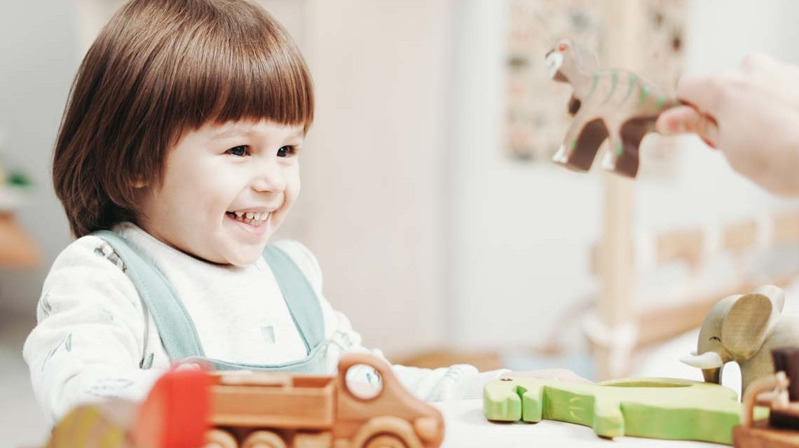 Tagesmüttervermittlung: Kind wird bespielt und lacht