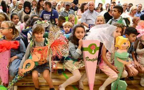 Schulstart: Erstklässler sitzen in der ersten Reihe, dahinter die Eltern in der Turnhalle der Freiherr-vom-Stein Schule