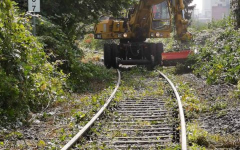 Bagger auf Schienen röäumt entlang der Aartalbahn auf.