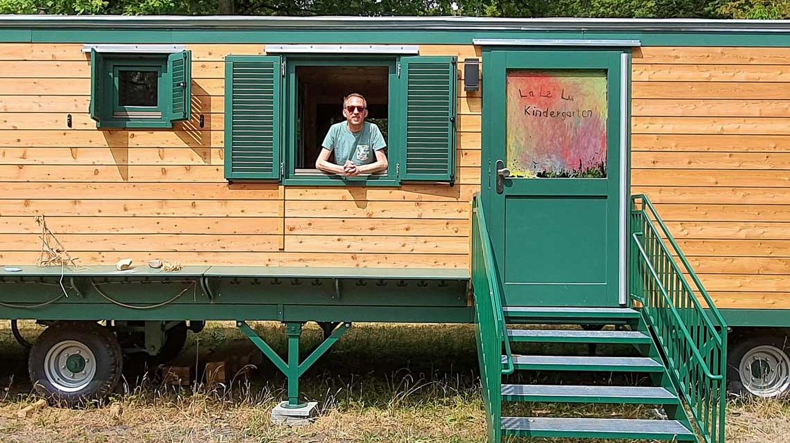 Christoph Manjura schaut aus einem Bauwagen heraus.