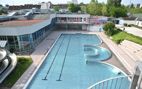 Blick auf leere Becken im Freibad Kleinfeldchen. Ein paar Schwimmer verlieren sich.
