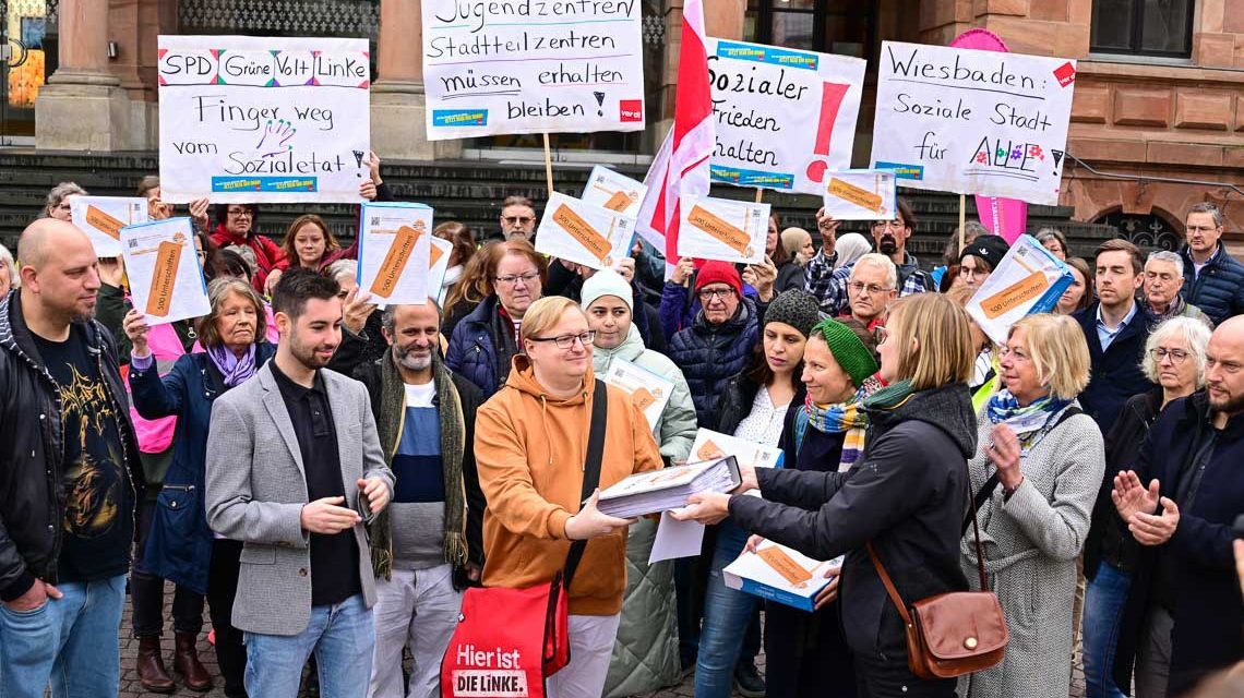 Nicole Nestler von der Evangelischen Kirche übergibt symbolisch einen Ordner mit 13000 Unterschriften.