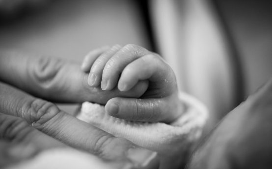 Geburts-Infoabend: Hand eines Babys greift nach Finger
