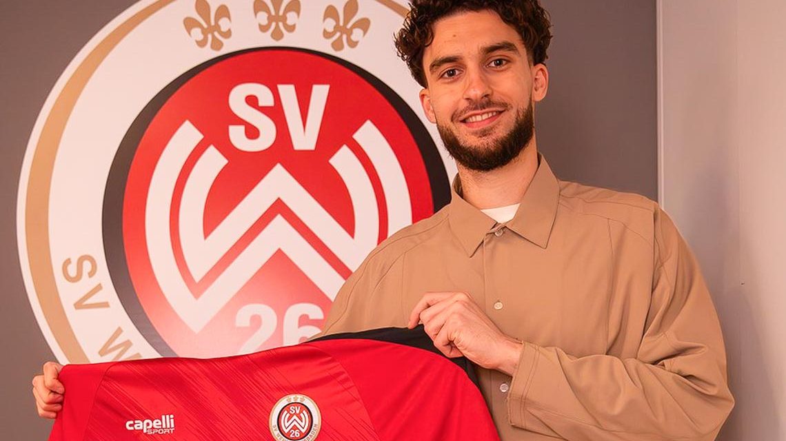 Nikolas Agrafiotis stellt sich vor, hält das Trikot des SVWW in den Händen.