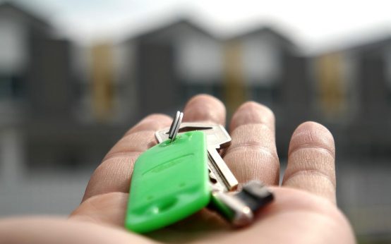 Wohnung mieten oder kaufen. Hand reicht Schlüssel. Wohnungsmarkt.