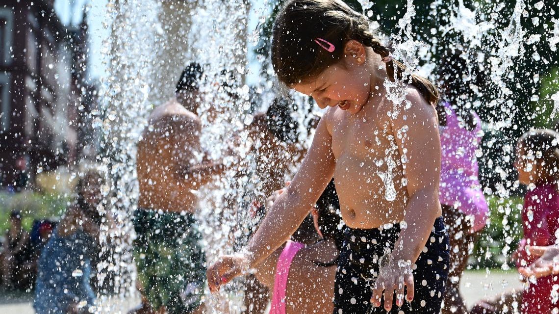 Kleines Mädchen vergnügt sich am Wasserspielplatz mit Wasserspiele.