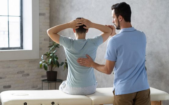 Physiotherapeut mit Patient in der Praxis.