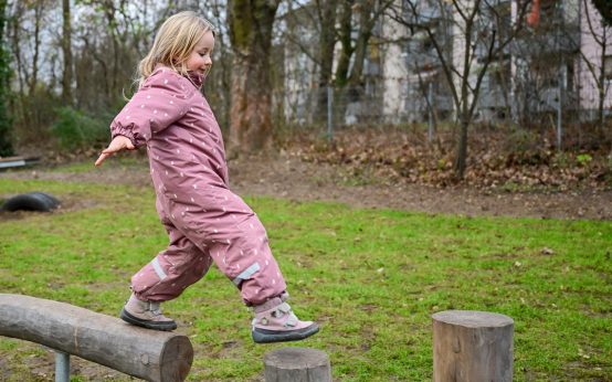 Kind auf Balancier-Element auf dem neuen Kinderspielplatz Wörthersee Straße.