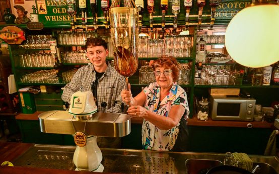 Lukas Schneider zapft ein Guiness und Irmgard Schneider eine Williams Birne.