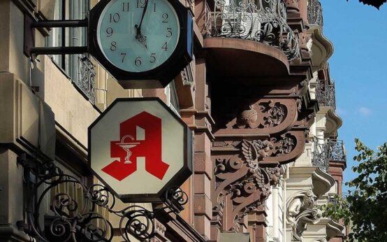 Taunusstraße, Wiesbadens Antiquitätenmeile im Wandel der Zeit. Das Bild zeit die Uhr und das Apothekenzeichen der Oranien-Apotheke.