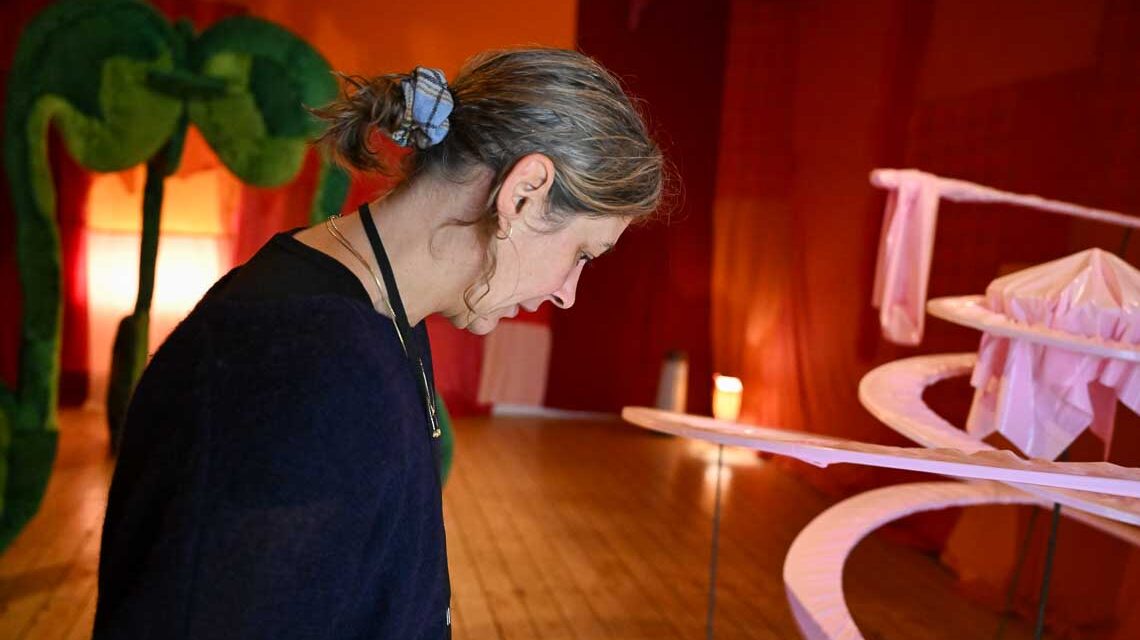 Lola Göller im Inneren einer roten Kirsche, im Innern ihrer Kunstinstallation.